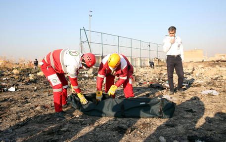epa08111623 Members of the International Red Crescent collect bodies of victims around the wreckage after an Ukraine International Airlines Boeing 737-800 carrying 176 people crashed near Imam Khomeini Airport in Tehran, killing everyone on board; in Shahriar, Iran, 08 January 2020.  EPA/ABEDIN TAHERKENAREH