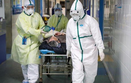 epa08201835 Medical staff move a 2019-nCoV patient into the isolation ward in a hospital in Wuhan, Hubei province, China, 06 February 2020 (issued 08 Ferbuary 2020). The nation is pulling medical resources from around the country to help the province, badly hit by the novel coronavirus outbreak.  EPA/YUAN ZHENG CHINA OUT