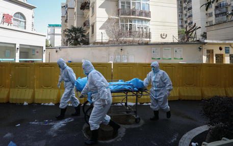 epaselect epa08223236 Workers move the body of a COVID-19 victim at a hospital in Wuhan, Hubei province, China, 16 February 2020. According to local authorities, the number of coronavirus cases in mainland China has reached over 70,000 with more than 1,660 related deaths.  EPA/STRINGER CHINA OUT