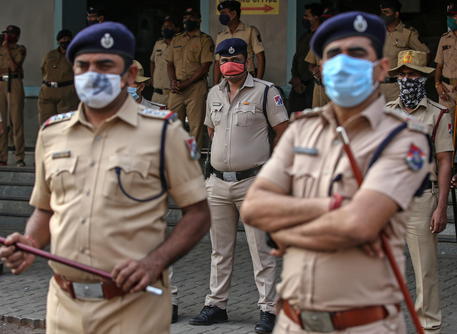 epa09021027 Mumbai Police and Railway Police Force personnel stands guard at the entrance of the railway station as left party activists and other social activists shouts anti-government slogans during a nationwide call for a four-hour train blockade protest outside Dadar railway station in Mumbai, India, 18 February 2021. Indian farmers and several supporting groups called for a four-hour Rail Roko Andolan (railway blockade) on 18 February to protest against the government's new agricultural laws and to demand for repealing the laws.  EPA/DIVYAKANT SOLANKI