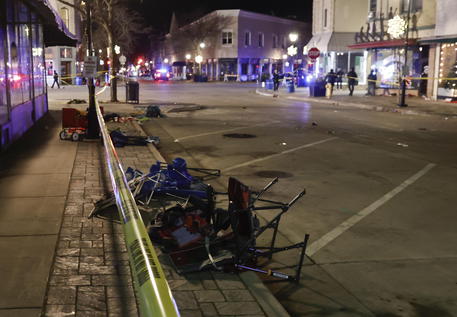 epa09597019 Debris left from crowds attending a Christmas parade lies scattered next to police crime scene tape after a SUV reportedly broke through a barricade and drove into  people including children leaving several people dead and many more injured in Waukesha, Wisconsin, USA, 21 November 2021. The vehicle was recovered by police and a person of interest is in custody.  EPA/TANNEN MAURY