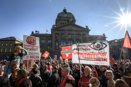 (FILES) In this file photo taken on October 23, 2021 thousands of protesters gather in front of the Swiss House of Parliament during a rally in opposition with the current measures to tackle the spread of the Covid-19, health pass and vaccination, in Bern. - The Swiss will vote on November 28, 2021 on the country's Covid-19 laws, after a campaign characterised by unprecedented levels of hostility in the wealthy Alpine nation, including even death threats. (Photo by Fabrice COFFRINI / AFP)