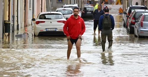 Pedestrians walk in a flooded street in the town of Lugo on May 18, 2023, after heavy rains caused flooding across Italy's northern Emilia Romagna region. Rescue workers searched on May 18, 2023 for people still trapped by floodwaters in northeast Italy as more residents were evacuated after downpours which killed nine people and devastated homes and farms. (Photo by Andreas SOLARO / AFP)